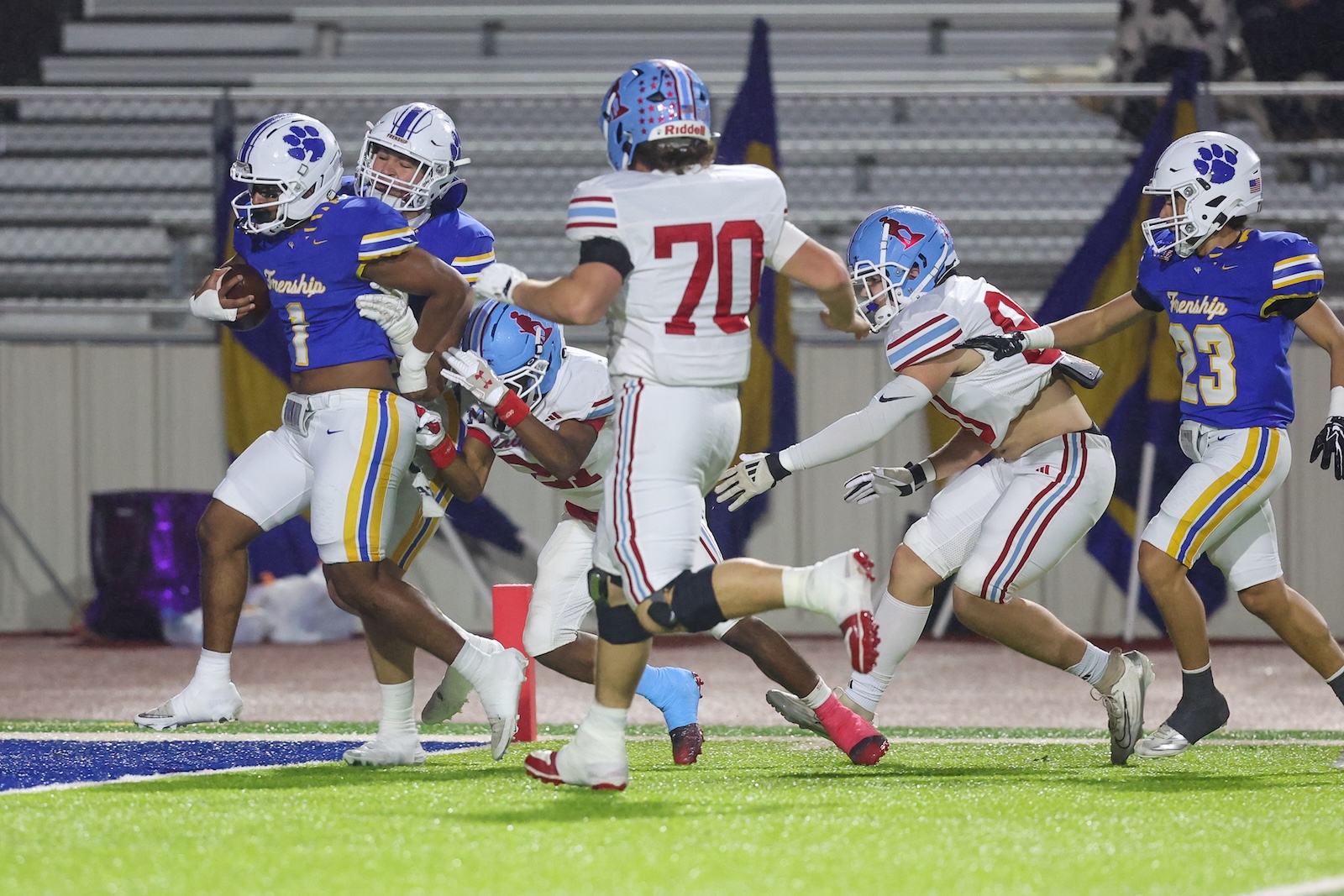 Seabolt Chase-19148 | Press Pass Sports Running back in blue and white carries the ball toward the end zone as defenders in white pursue far behind him.